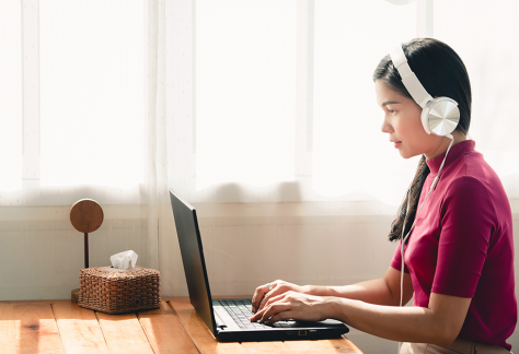 Woman with headsets on her laptop