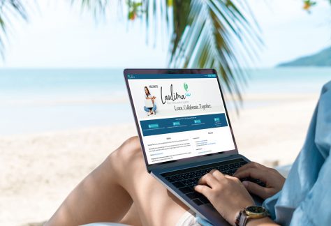 Woman on beach with laptop